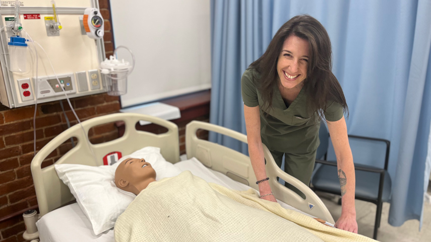 CNA student at simulation patient bed