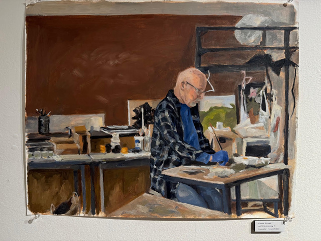 oil painting of old man working at desk in cluttered studio. He is very focused and wearing flannel.