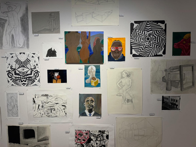 a collection of student pieces on the gallery wall